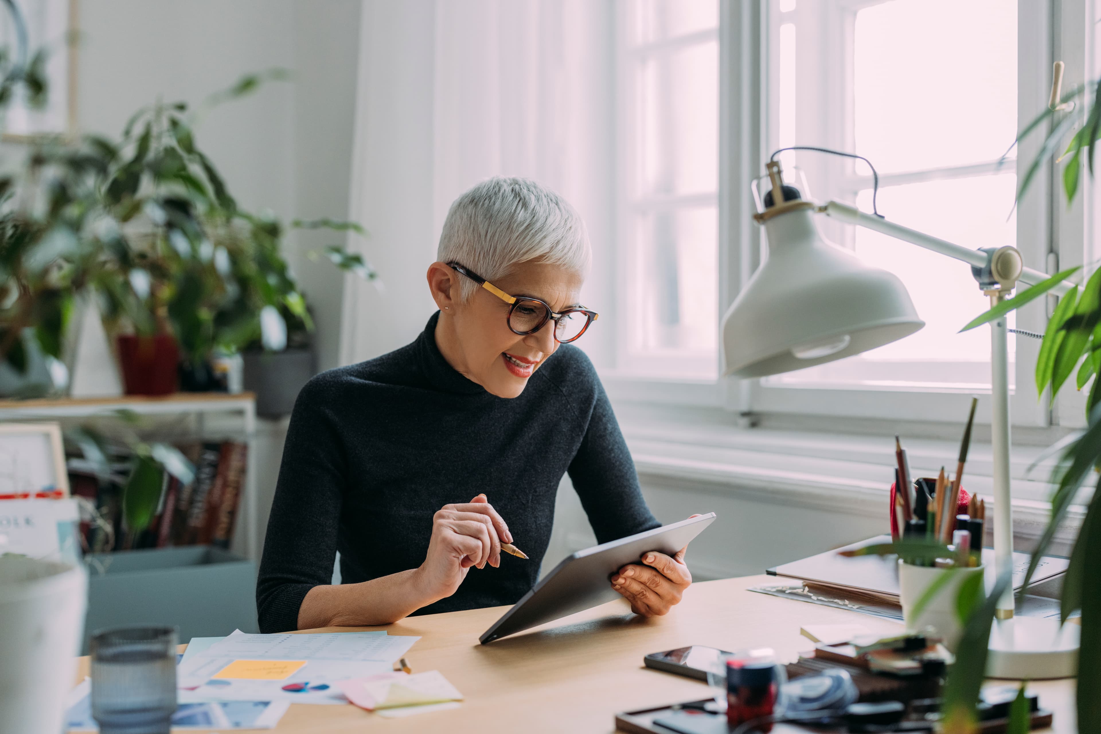 Woman reviewing savings and investment paperwork at a desk